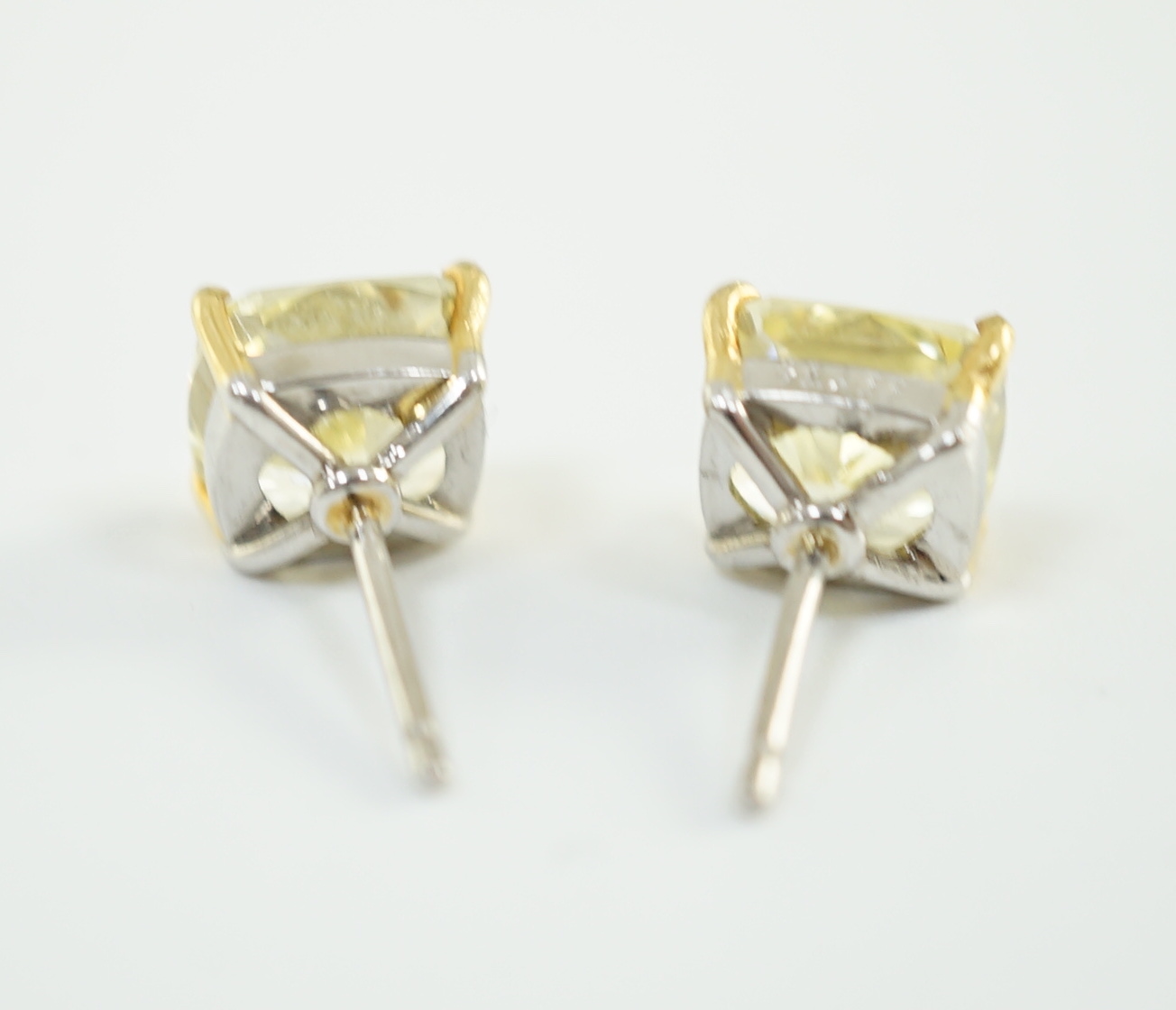 A fine pair of Graf platinum and 18ct white gold set cushion modified brilliant cut natural fancy yellow diamond ear studs